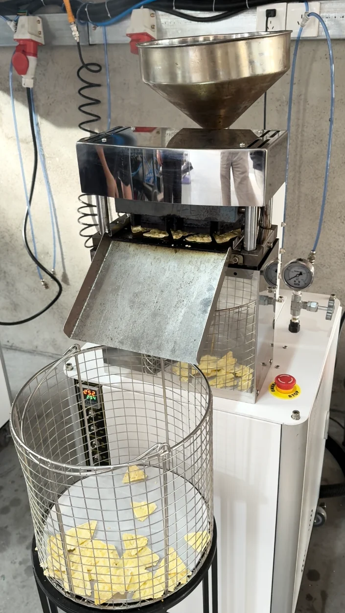 Machine showing hopper, press, chute and collection basket